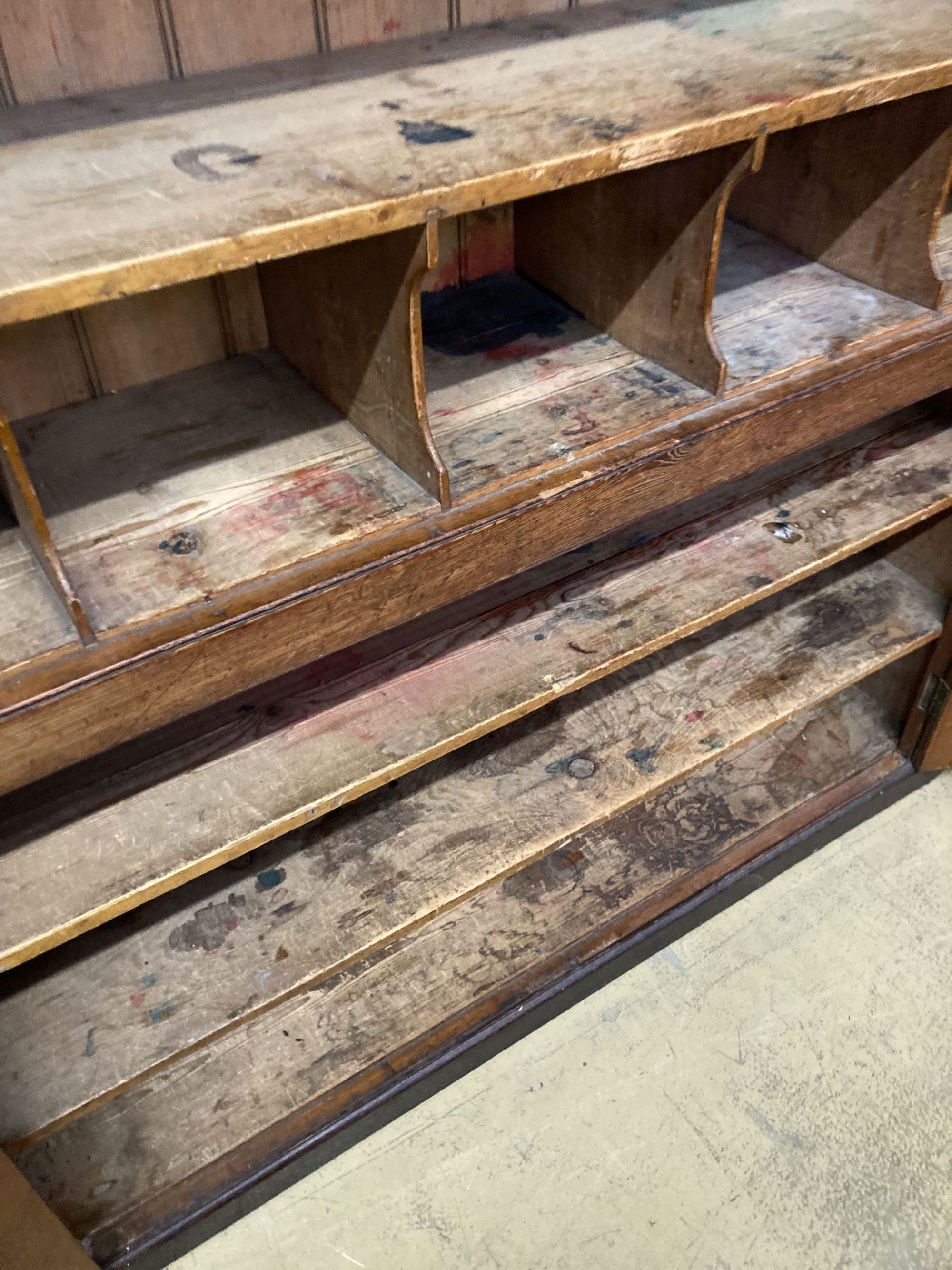 A Victorian panelled pitch pine four door cabinet, upper section marked in gilt, Newnham Girls College Cambridge music sheets and book